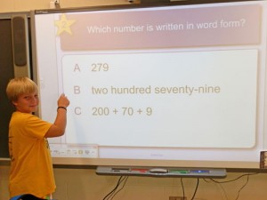 OC Elementary Students Answer Questions On Smart Board