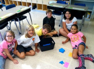 Third Grade Students AT OC Elementary Manipulate Base 10 Blocks In Giant Place Value Chart