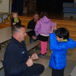 OC firefighter/paramedics Eric Peterson, front, and Mike Maykrantz helped students at Ocean City Elementary School try on their new winter coats.