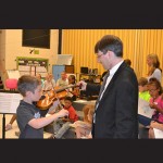 Violinist Nicholas Currie shows a student how to play violin. Photos by Charlene Sharpe