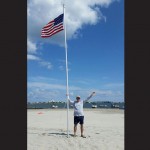 Smith is pictured with the flag pole he assembled along with a group of strangers last Sunday on Dog and Bitch Island in the Isle of Wight Bay. Submitted Photos