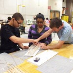 Stephen Decatur High School technology teacher Dale Krantz assists incoming freshmen Ka'Mell Tatum and Genesis Mena with securing the sides of their truss bridge during the Summer Academy.