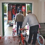 Volunteers are pictured loading bikes on Monday morning that were donated to the Santa House beyond this year’s deadline and will be given away next year to a needy family. Photos by Charlene Sharpe