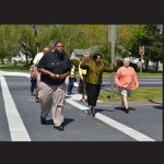 Quintin Dennis, father of a teenager killed near the intersection, walks across Route 113 with supporters and town officials. Photos by Charlene Sharpe