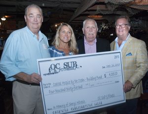 OC SUP & Fitness Presents Check To Go Towards Building The Macky & Pam Stansell House At Coastal Hospice